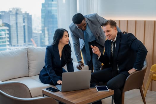 Diverse business team looking at laptop while discussing about business idea. Group of happy manager talking , thinking sharing business strategy while young businesswoman using laptop. Ornamented.