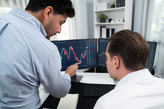 Stock exchange traders discussing digital currency or market online focusing on real time dynamic data with two screen, analyzing increased possible trend investment at modern workplace. Sellable.