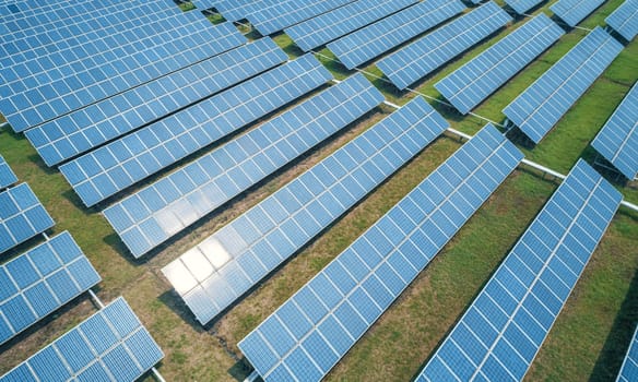 Aerial shot of solar panels farm on the green field. Renewable alternative green energy concept.