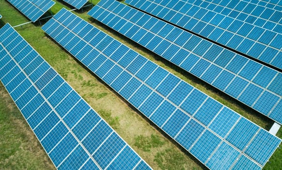 Aerial shot of solar panels farm on the green field. Renewable alternative green energy concept.