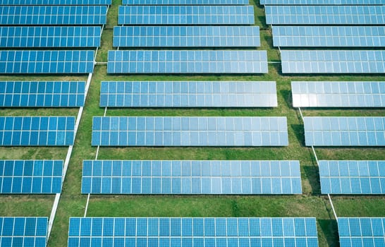 Aerial shot of solar panels farm on the green field. Renewable alternative green energy concept.