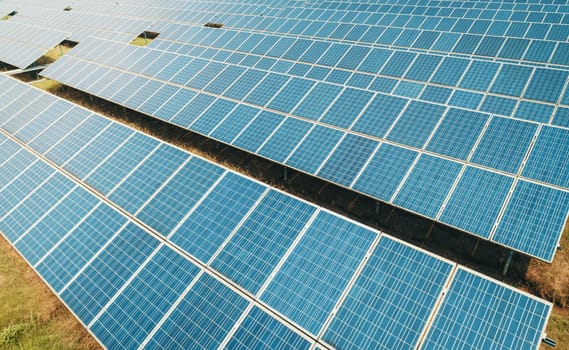 Aerial shot of solar panels farm on the green field. Renewable alternative green energy concept.