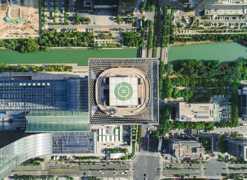 Aerial drone view of helipad on the roof of a skyscraper in downtown.