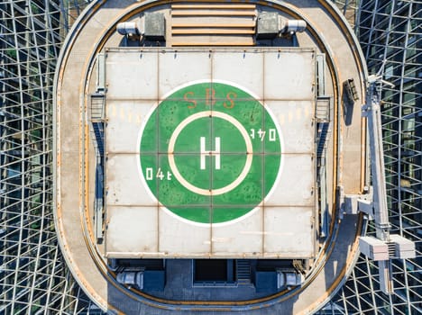 Aerial drone view of helipad on the roof of a skyscraper in downtown.