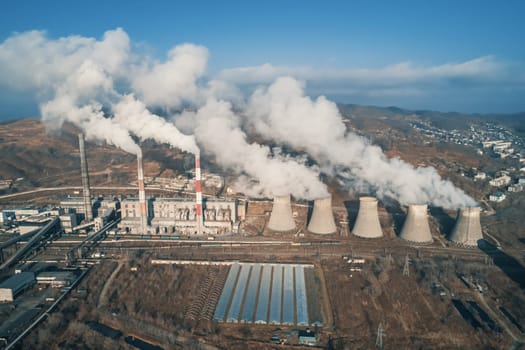 Aerial view of smoking pipes and cooling towers of coal thermal power plant