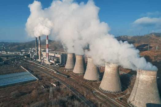 Aerial view of an industrial zone pipes pouring thick white smoke. Thick smoke plumes. Thermal power plant pipes, air pollution.