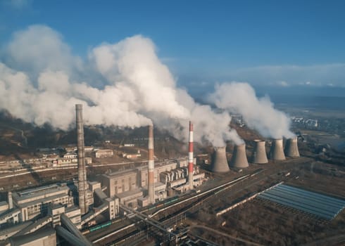 Aerial view of smoking pipes and cooling towers of coal thermal power plant