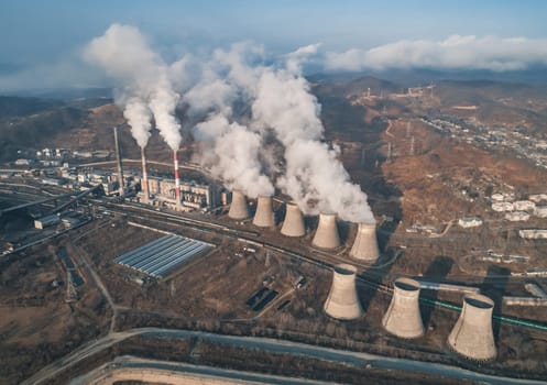 Aerial view of smoking pipes and cooling towers of coal thermal power plant