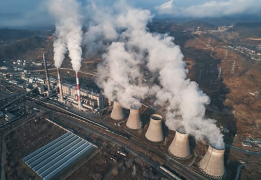 Aerial view of smoking pipes and cooling towers of coal thermal power plant