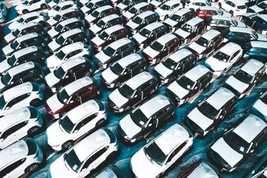 Aerial view of new cars parked in car parking lot. Car dealer parking lot full of new automobiles. New cars lined up for import and export business.