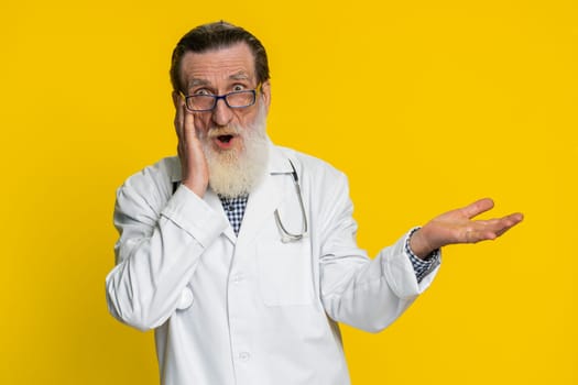 Oh my God Wow. Excited amazed winner senior elderly doctor cardiologist man surprise looking at camera big eyes shocked by victory celebrating success. Apothecary pharmacy grandfather. Copy-space
