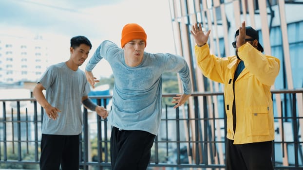 Hip hop team dance break dance while multicultural friend surrounded and clapping hands to cheer or encourage his friend to dance. Active and energetic street dance. Outdoor sport 2024. Endeavor.