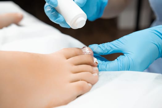 Application of antibiotic powder proves effective in combating toenail ailments caused by fungal or bacterial infections on female toe, such as athletes foot or toenail fungus by podologist