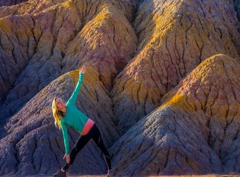 A woman stretches in a yoga pose at Clay Beds in Southern Utah