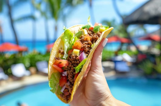 Close up of hand holding up an open taco against a tropical resort on a sunny day.