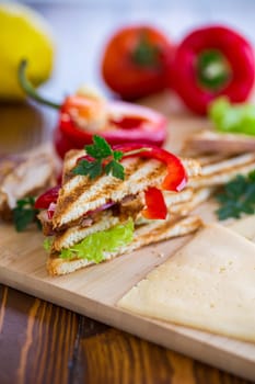 fried toast with chicken, salad, greens on a wooden table .