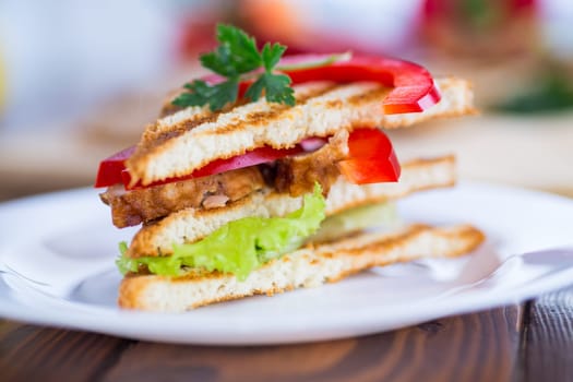 fried toast with chicken, salad, greens on a wooden table .