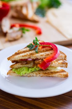 fried toast with chicken, salad, greens on a wooden table .