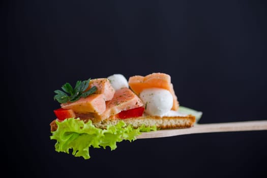 fried toast with salmon, cream cheese, salad, isolated on black background .