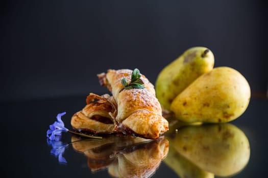Sweet pastries, puff pastries with pears, isolated on black background .