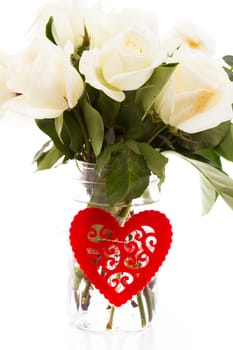 Bouquet of white roses in vase with red heart.