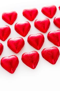 Heart shape chocolate candies on white background.