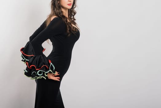 Portrait of beautiful young woman dancing flamenco with fan in studio