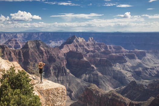 A woman is entranced by the immense beauty of the Grand Canyon at The North Rim, Arizona