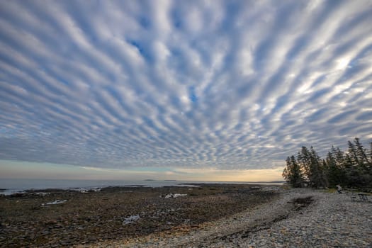 The tide is out and funky clouds appear at Seawall Beach  at Acadia National Park, Maine