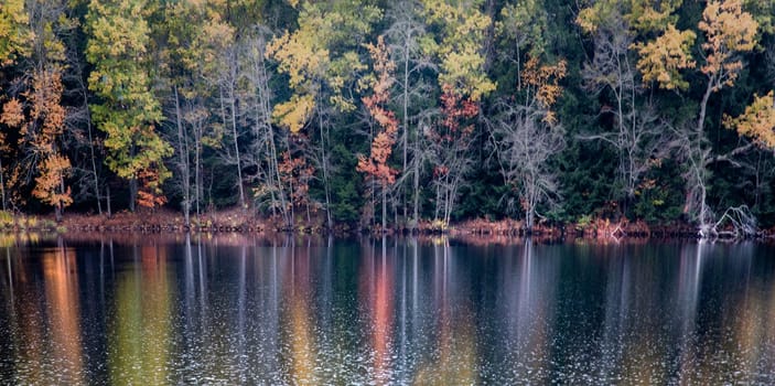 Fall colors are reflected in a lake in rural New Hampshire