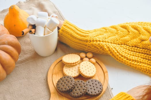 Pumpkin Cookies With Cups Of Coffee. Autumn winter pastries. Cozy atmosphere, warm knitted sweater, girl drink coffee, hands in picture.