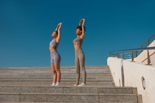 Young sportswomen in tracksuit are stretching outdoor and preparing to jogging. Healthy life concept