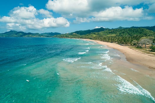 Aerial view of tropical sandy beach in bay with blue water. Seascape with sea, sand, palm trees. Top view of paradise island.