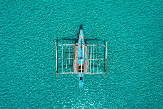 Aerial drone view of boat anchored in the bay with clear and turquoise water. Boat in the tropical lagoon. Tropical landscape.