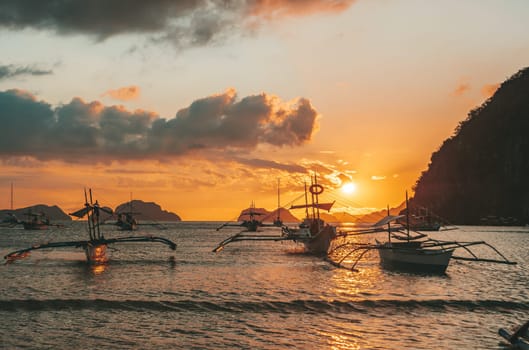 Beautiful sunset with silhouettes of philippine boats in El Nido, Palawan island, Philippines