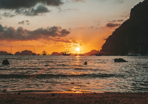 Beautiful sunset with silhouettes of philippine boats in El Nido, Palawan island, Philippines