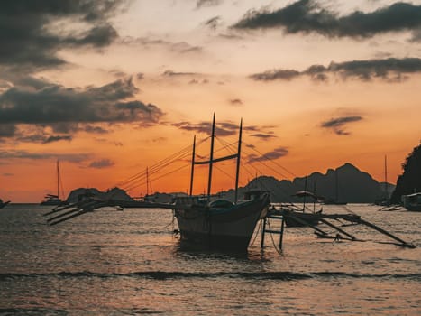 Beautiful sunset with silhouettes of philippine boats in El Nido, Palawan island, Philippines