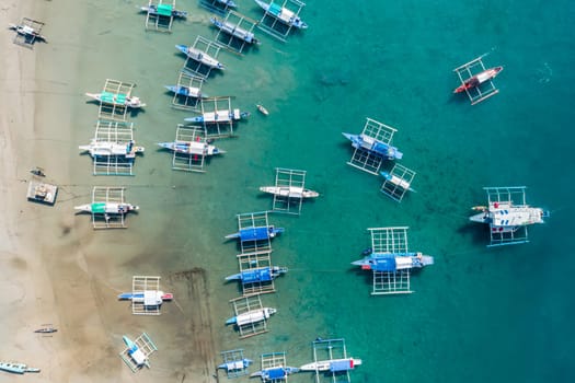 Top drone view of a traditional philippine boats on the surface of the azure water in the lagoon. Summer and travel vacation concept