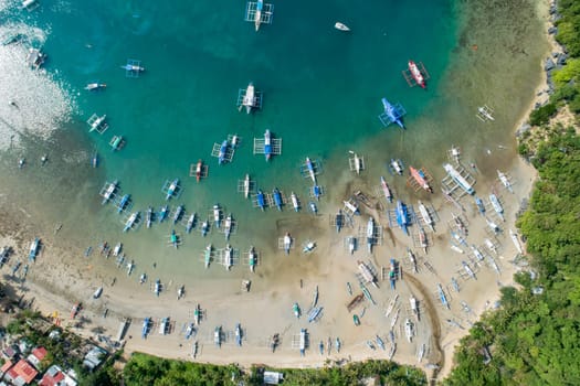 Top drone view of a traditional philippine boats on the surface of the azure water in the lagoon. Summer and travel vacation concept