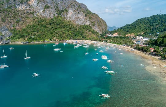 Drone view of a traditional philippine boats on the surface of the azure water in the lagoon. Summer and travel vacation concept. El Nido, Philippines.