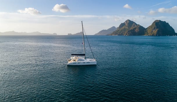 Aerial drone view of sailing yacht anchored in the bay with clear and turquoise water. Sailing yachtin the tropical lagoon.