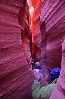 Hikers make their way through the narrow slot canyon called Spooky Gulch at The Grand Staircase-Escalante National Monument in Utah.