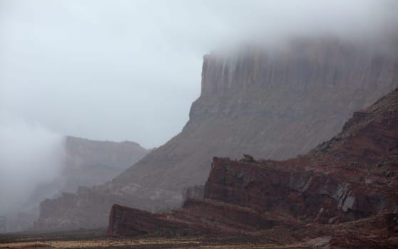 A passing rainstorm brings some clouds, fog and  dramatic looks to the landscape at The Island In The Sky District at Canyonlands National Park, Utah