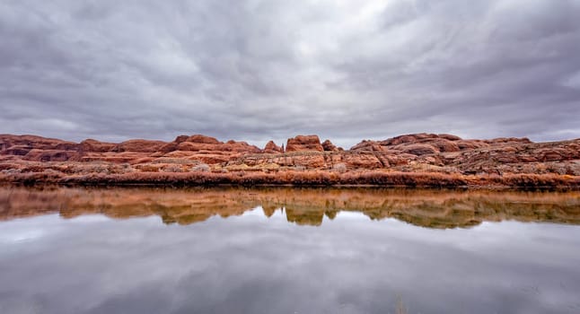 Sandstone formations are reflected in the still Colorado River near Moab, Utah.