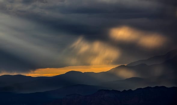 Stormy skies pass through the Southern Utah landscape and produce sunbeams at sunset