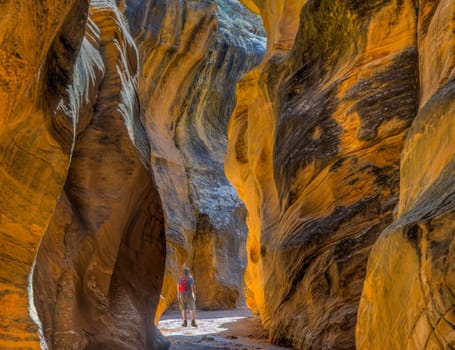 A hiker observes the colorful canyon walls of Willis Creek in Southern Utah's Grand Staircase Escalante National Monument