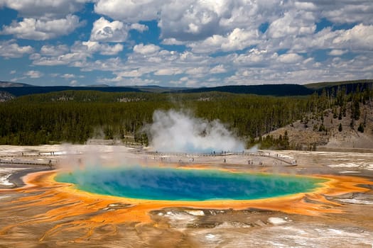 GRAND PRISMATIC SPRING STANDS OUT AGAINST THE WYOMING SKY IN THE MIDWAY GEYSER BASIN IN YELLOWSTONE NATIONAL PARK.