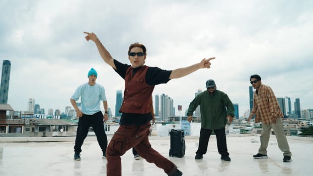 Professional break dance team practice B-boy dance while multicultural friends at rooftop. Young modern dancing group doing hip hop movement. Style,fashion,action. Outdoor sport 2024. Endeavor.