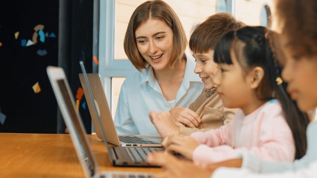 Smart teacher teaching and looking student using laptop at classroom. Professional instructor explained about programing engineering code or prompt while studying and learning program. Erudition.