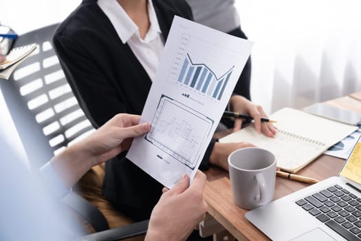 Diverse group of business analyst team analyzing financial data report paper on office table. Chart and graph dashboard by business intelligence analysis for strategic marketing planning Meticulous